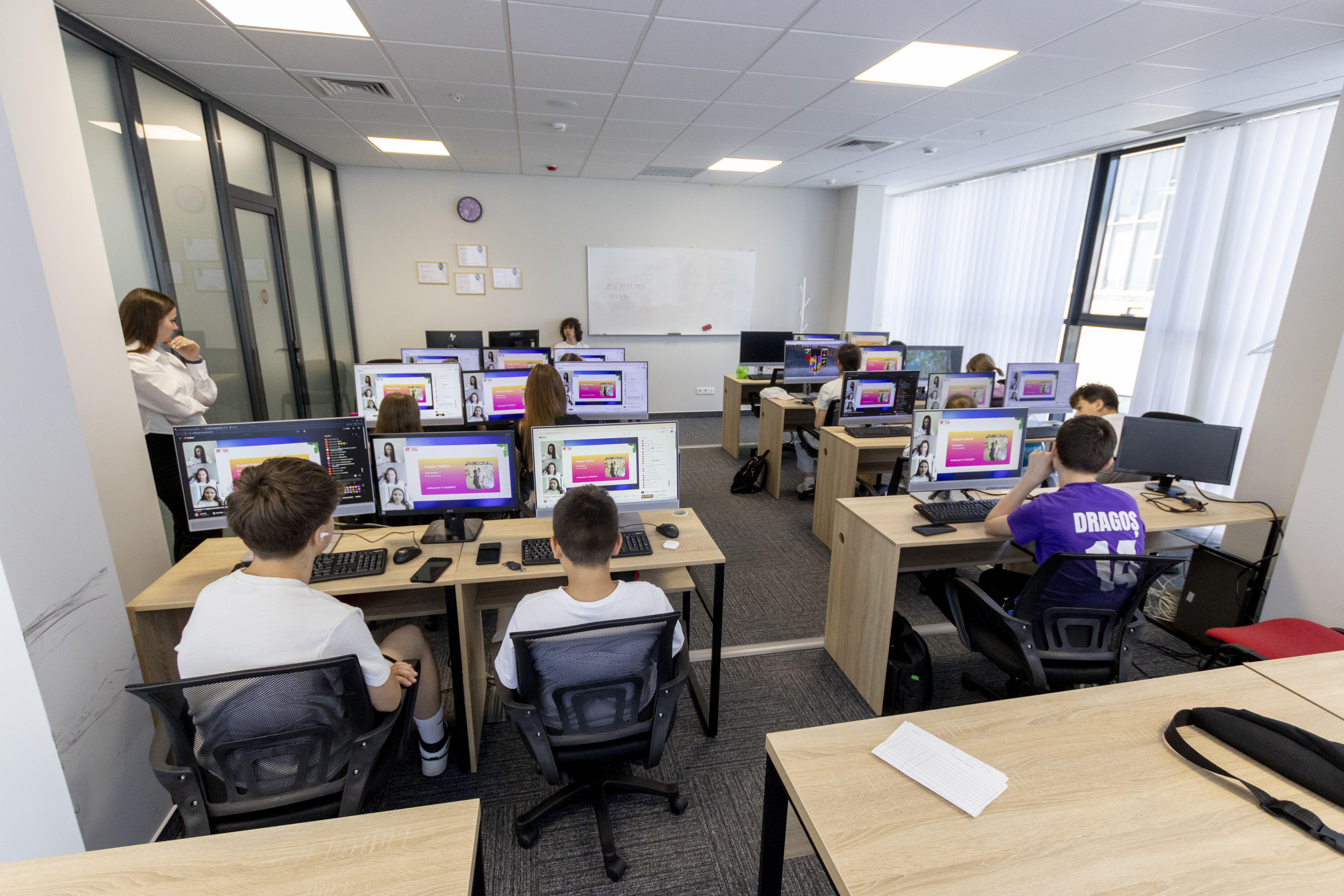 Elevi lucrând la calculatoare